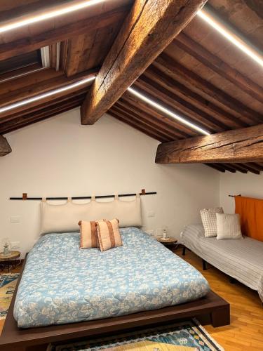 a bedroom with a large bed with wooden ceilings at Chez Madame in Ferrara