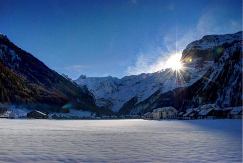 a snow covered mountain with the sun shining on it at Hotel Garni Hostatt in Engelberg