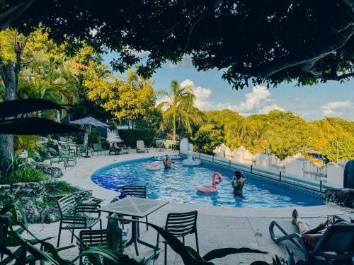 a pool at a resort with people playing in it at Viajero Bacalar Hostel in Bacalar