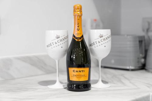a bottle of wine sitting next to two wine glasses at Stylish 2 Bed Apartment - Balcony - Private Parking - Netflix 4MC in Birmingham