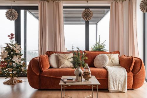 Wichrowy Domek في نوفه تارخ: غرفة معيشة مع أريكة بنية و شجرة عيد الميلاد