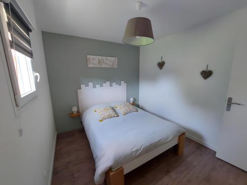 een kleine slaapkamer met een wit bed en een raam bij Gîte Ô Et Nature in Saint-Viaud