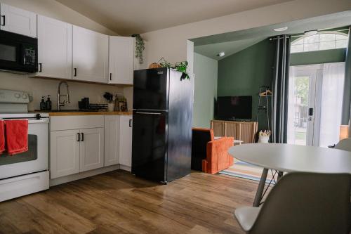 Una cocina con un refrigerador negro y una mesa. en Mile High Hideaway, en Denver