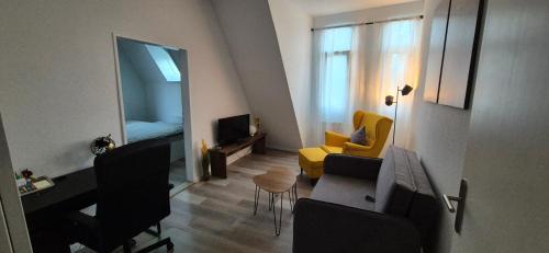 a living room with a couch and a yellow chair at Midtown Geeste Appartement - Free Parking & WiFi in Bremerhaven