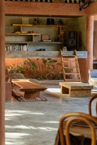 a room with tables and chairs and a book shelf at Lulu's Wellness Boutique Villas in Uluwatu
