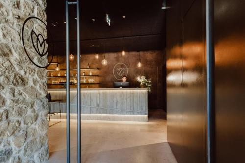a lobby with a counter and a stone wall at Naturhotel Die Maise in Hayingen