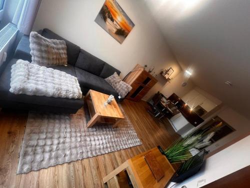 ein Wohnzimmer mit einer schwarzen Couch und einem Couchtisch in der Unterkunft Lord Nelson Apartment 14 in Cuxhaven