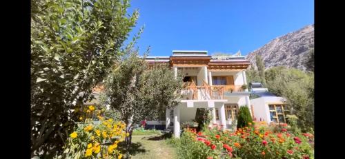 a house in a garden with flowers at Baltipa Homestay in Pānāmik
