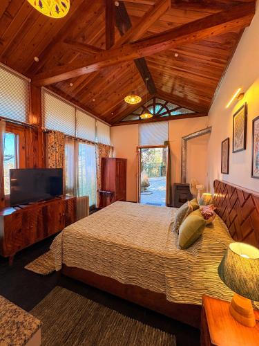 a bedroom with a large bed in a room with wooden ceilings at Rock Villa by Baaya in Mussoorie