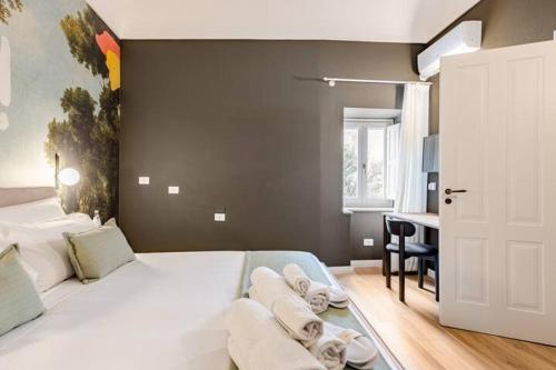 a bedroom with a white bed with towels on it at xenia apartments & suite in Siracusa