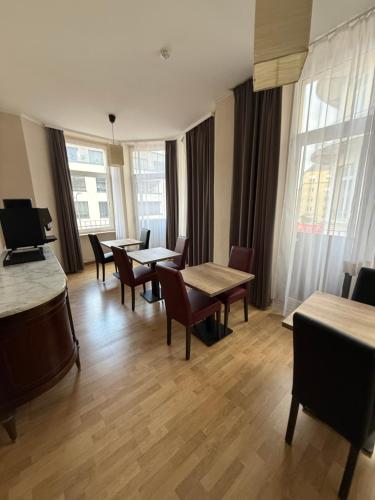 a dining room with tables and chairs and windows at Suite Mondorf-les-bains in Mondorf-les-Bains