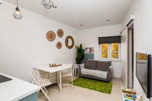 a kitchen and living room with a table and a chair at Duplex com Vista Mar a Passos da Praia - Just Sezimbra in Sesimbra