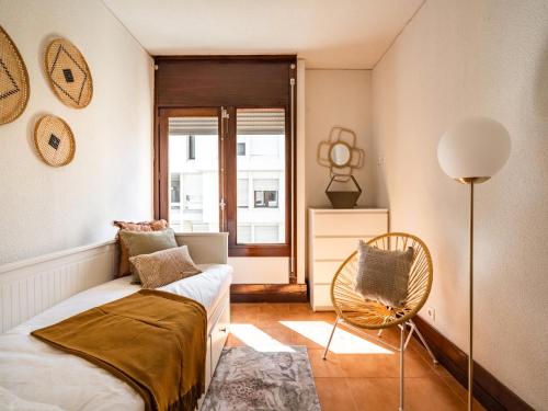 a bedroom with a bed and a chair and a window at Akisol Troia Apricot in Troia