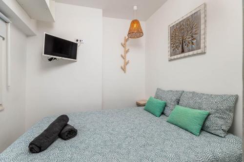 a bedroom with a bed with a pillow and a tv at Duplex com Vista Mar a Passos da Praia - Just Sezimbra in Sesimbra
