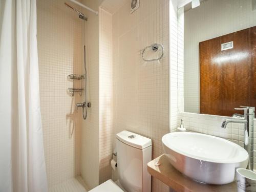 a bathroom with a sink and a toilet and a mirror at Akisol Troia Apricot in Troia
