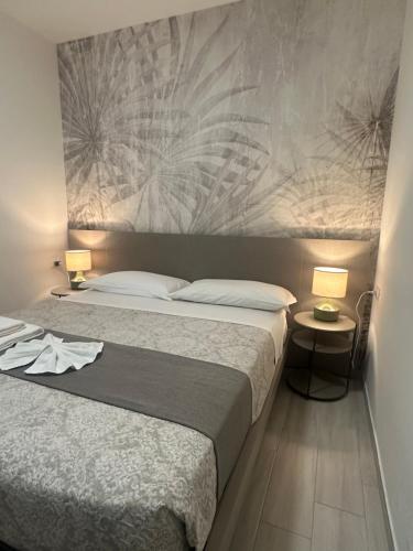 a bedroom with a large bed and two lamps at The Rooms Catanzaro Lido in Catanzaro Lido