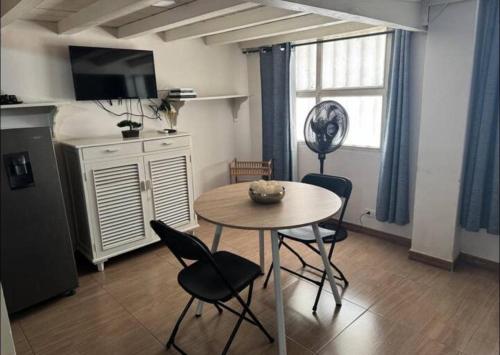 Exclusive Studio Apartment in the Old City Cartagena في كارتاهينا دي اندياس: مطبخ مع طاولة وكراسي في الغرفة