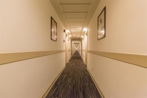 an empty corridor in a building with paintings on the walls at Jinjiang Inn - Yancheng East Huanghai Road Zhaoshang Hotel in Yancheng