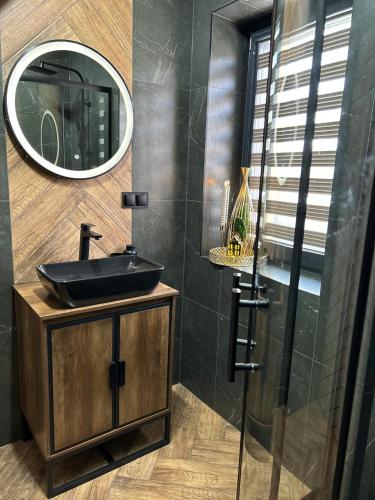 a bathroom with a sink and a mirror at Tatra House z Jacuzzi in Poronin