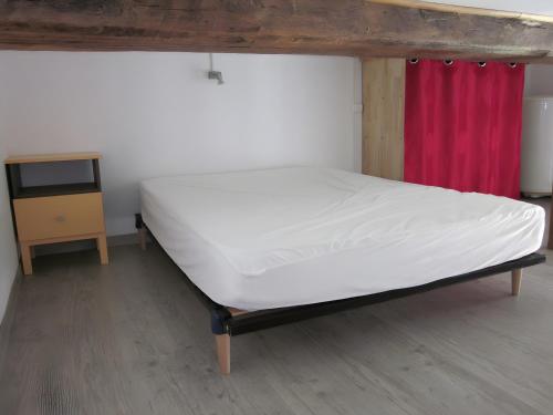 a bed in a room with a tv and a bedskirtspectspectspectspects at Douillet F1 Place Paoli in Corte