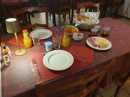 Una mesa con platos de comida y bebidas sobre ella. en Hôtel de la promenade, en Bains-les-Bains