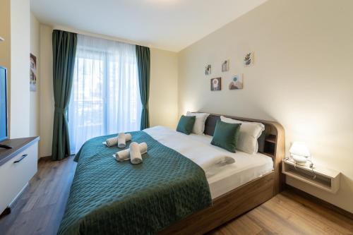 Stylish 1BR Flat Garden Balcony Parking في مدينة فارنا: غرفة نوم مع سرير مع دبتين عليه