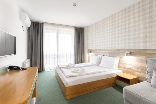 a hotel room with a bed and a couch at Hotel Iceberg Bansko in Bansko