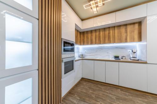 Stylish 1BR Flat Garden Balcony Parking في مدينة فارنا: مطبخ مع دواليب بيضاء ونافذة كبيرة