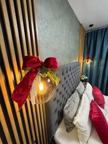 a bedroom with a bed with a red bow on it at Aici te simți ca acasa in Iaşi