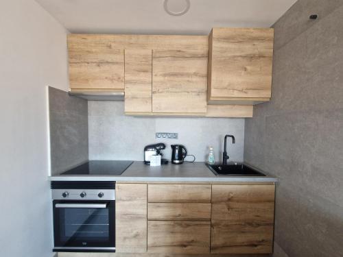 una cucina con mobili in legno e un lavello di Renovated & Comfortable Apartment with Lift a Castellón de la Plana