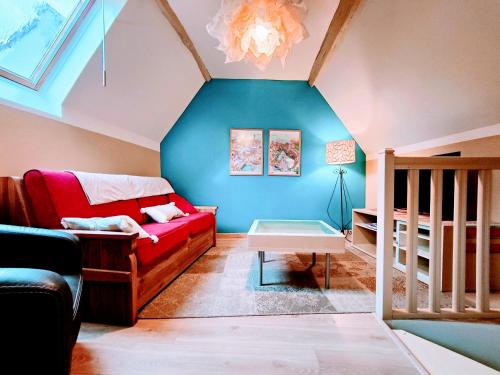 ein Wohnzimmer mit einem roten Sofa und einer blauen Wand in der Unterkunft Chez Maméta - Séjour à Auxerre in Auxerre