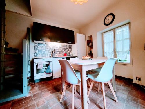 eine Küche mit Tisch, Stühlen und einer Uhr in der Unterkunft Chez Maméta - Séjour à Auxerre in Auxerre