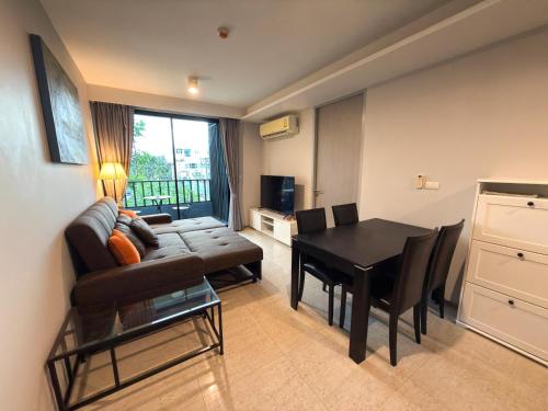 ein Wohnzimmer mit Sofa und Tisch in der Unterkunft 6th Avenue 2 bedroom in Surin Beach