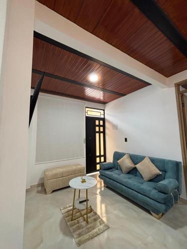 Apartamento Jardines Guaduas Cundinamarca في غوادواس: غرفة معيشة مع أريكة زرقاء وطاولة