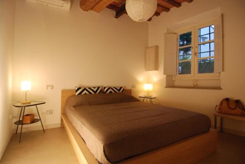 a bedroom with a bed with two tables and two lamps at S. Agostino Fronte Mura in Lucca