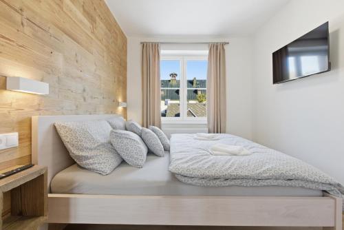 una camera da letto con un letto con cuscini e una televisione di Apartmán Géčko a Boží Dar