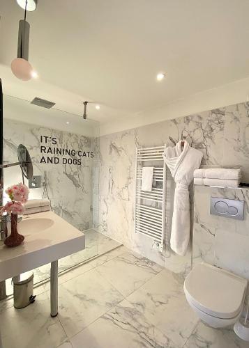 a bathroom with a toilet and a marble wall at Hôtel Cannes Centre Univers in Cannes