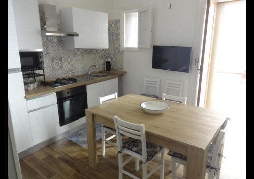 una cucina con tavolo e sedie in legno di Thalìa a Trapani