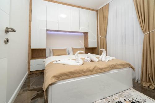 a bedroom with a bed with white towels on it at Apartmani Deluxe in Sanski most