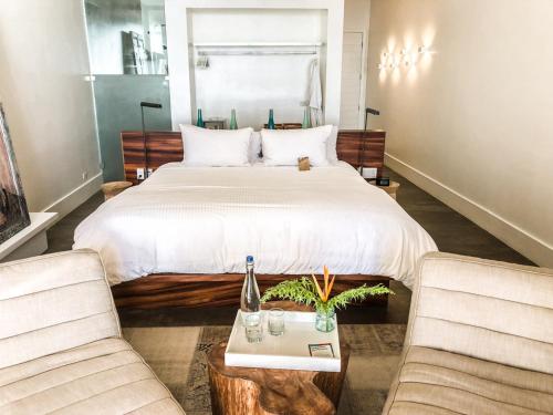 a bedroom with a large bed and two chairs at Ibagari Boutique Hotel in Roatan