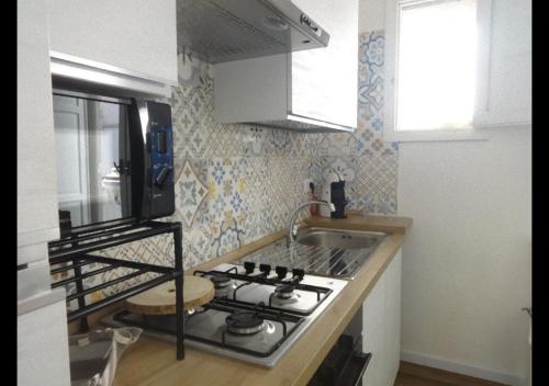 una cucina con fornelli e lavello di Thalìa a Trapani