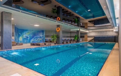 a large swimming pool in a large building at Litz Resort in Kvariati