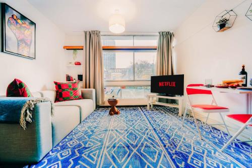a living room with a couch and a tv at Central & Stylish with Pool & Gym Barbican Accomodation in London