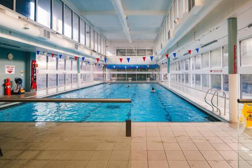 a large indoor swimming pool with two cues in it at Central & Stylish with Pool & Gym Barbican Accomodation in London