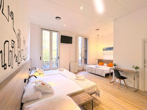 a room with two beds and a desk in it at lullaby by hamilton in Barcelona