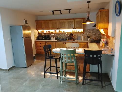 eine Küche mit Tisch und Stühlen und einem Kühlschrank in der Unterkunft Dar Sabrina Bizerte Corniche in Banzart
