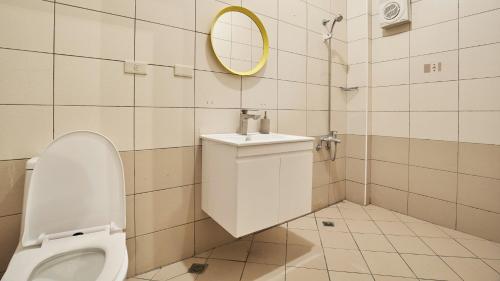 een badkamer met een toilet en een spiegel bij 約旦河民宿包棟附電動麻將 in Hsia-ch'ing