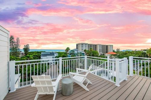 a balcony with white chairs and a view of the ocean at Gulfside Green Estate in Siesta Key