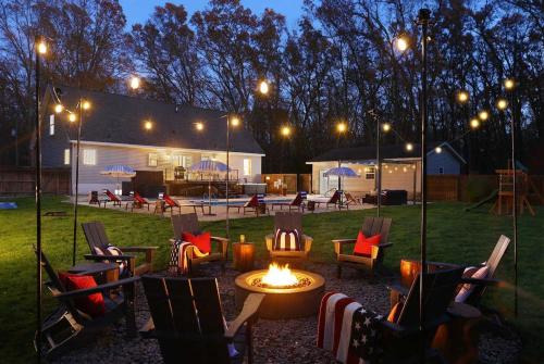 Pine & Paddle Getaway Game Room Hot Tub Pool في مسكيغون: حفرة نار في ساحة في الليل