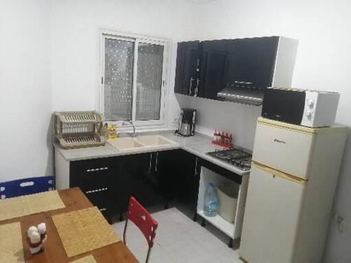 une petite cuisine avec un évier et un réfrigérateur dans l'établissement Diar Amina, à Midoun